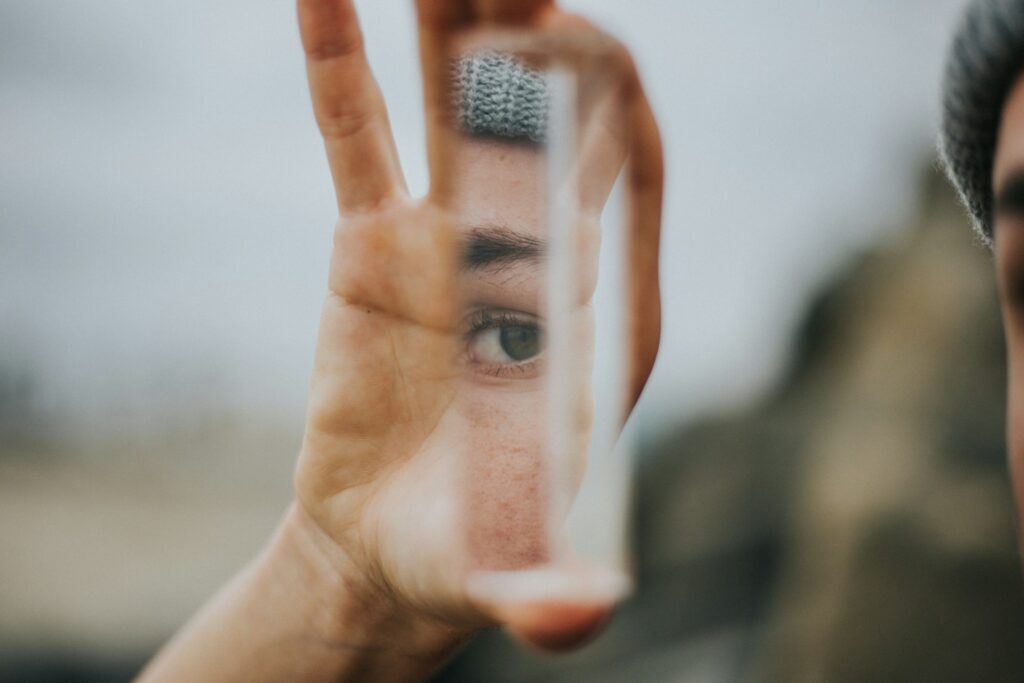 Blurred photo of person holding mirror to self.